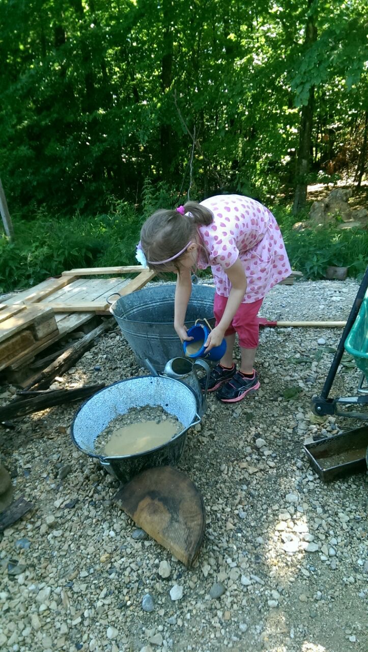 Ein Kind wäscht Steine in einer Schüssel.